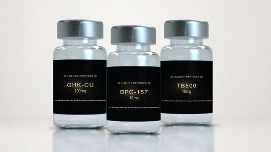 Three Luxury Peptides research vials labeled BPC-157 10mg, TB-500 10mg, and GHK-Cu 100mg displayed on a neutral background with a soft reflective surface.