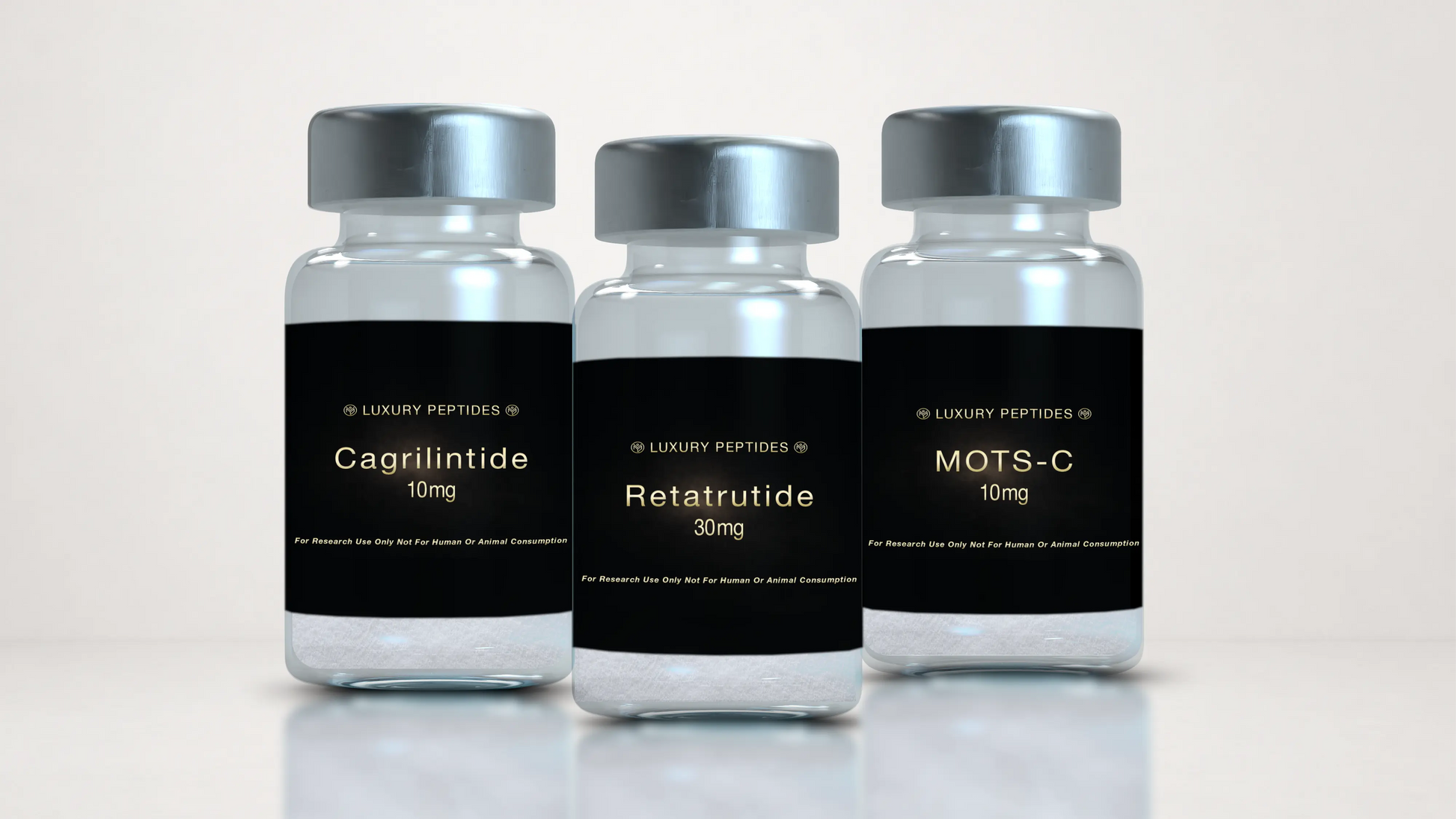 Three Luxury Peptides research vials labeled Cagrilintide 10mg, MOTS-C 10mg, and Retatrutide 30mg displayed on a neutral background with a soft reflective surface.