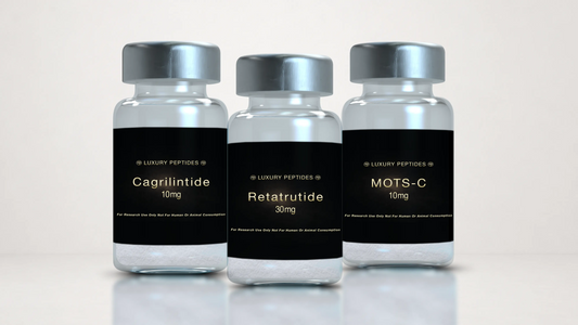 Three Luxury Peptides research vials labeled Cagrilintide 10mg, MOTS-C 10mg, and Retatrutide 30mg displayed on a neutral background with a soft reflective surface.
