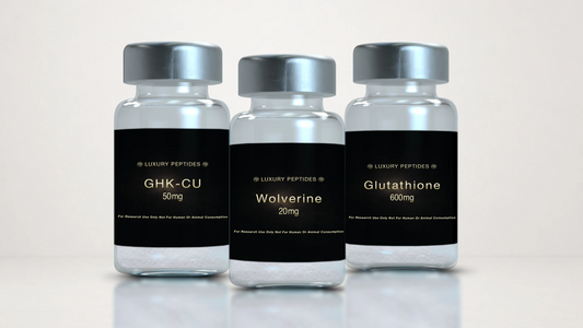 Three Luxury Peptides research vials labeled Wolverine 20mg, GHK-Cu 50mg, and Glutathione 600mg displayed on a neutral background with a soft reflective surface.